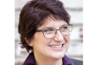 Person smiling in a blurred out classroom