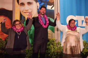 Group of people posing for a picture with leis around their necks.