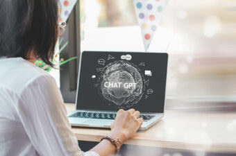 Photo of woman looking at laptop screen with ChatGPT
