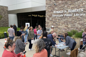 People gathered outside a public school library.