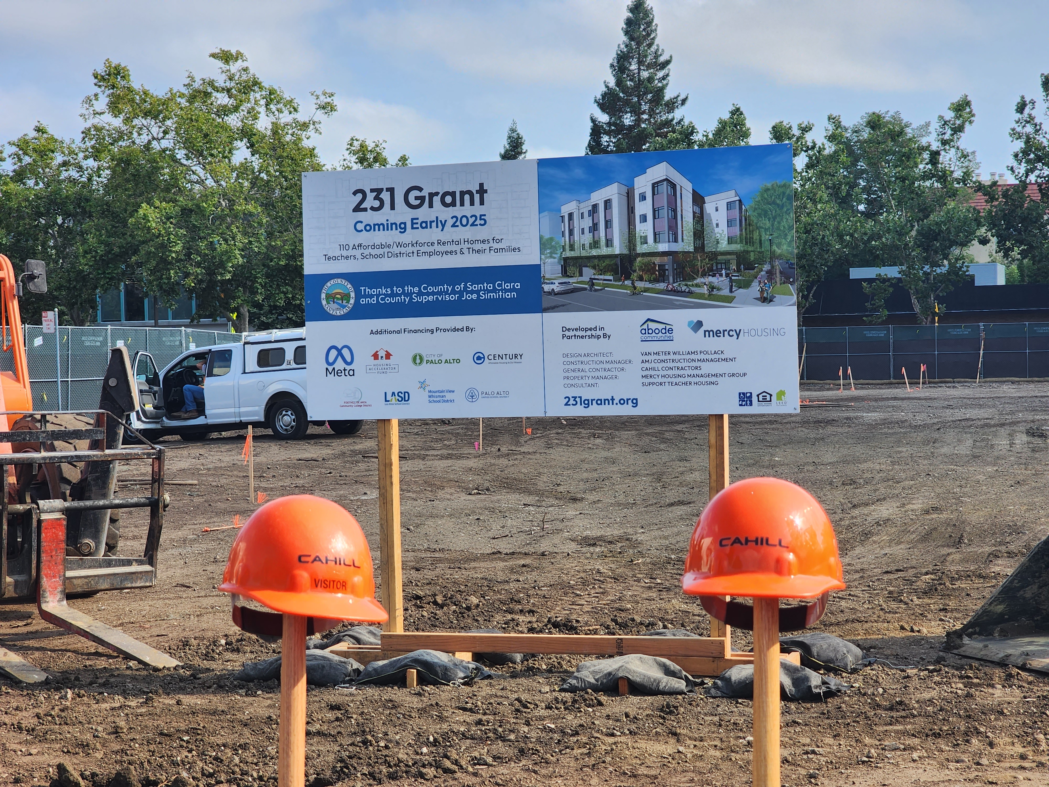 a sign and two orange hard hats