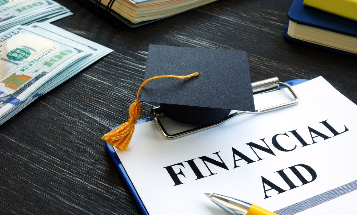 Photo of a financial aid application and a graduation cap.