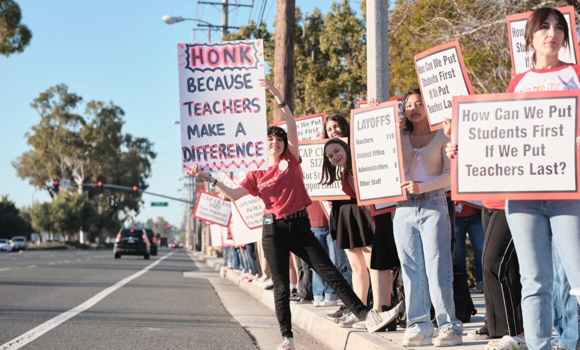 Anaheim Secondary Teachers Association members with signs against layoffs