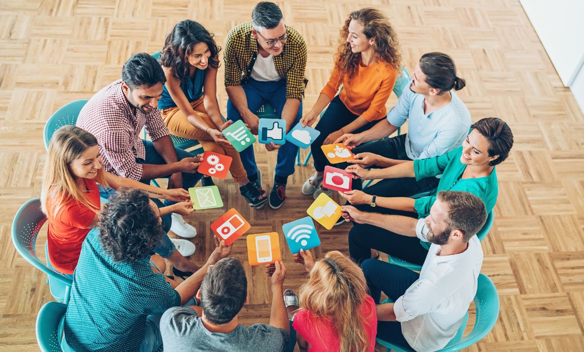 Photo of a circle of people holding social media cards.