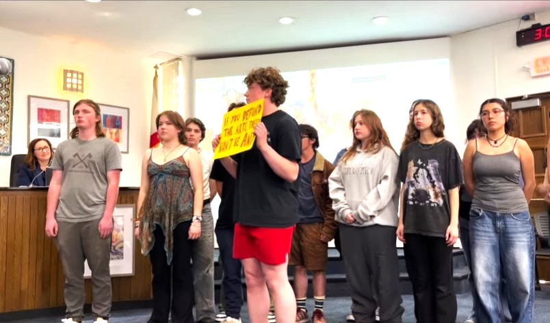Santa Barbara High School students, whose theater teacher received aRIF notice, were expected to perform at the district school board in April. Instead, they stood in silence for minutes before unfolding a sign that said, “If you defund the arts, there won’t be any.” The notice was later rescinded.
