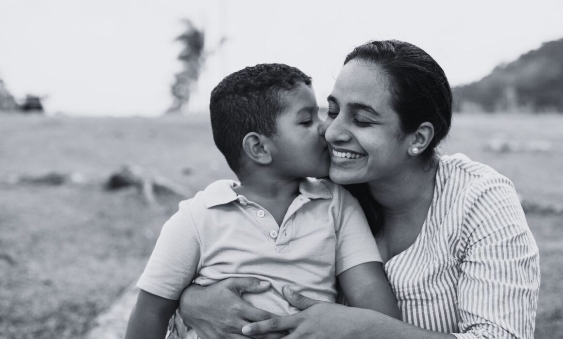 Image of a woman smiling while holding a child.