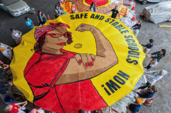 Educators, students, families and community allies helped paint this parachute, whose Rosie the Riveter is modeled after UTR member Miesha Gash.