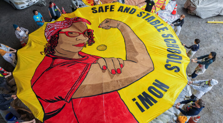 Educators, students, families and community allies helped paint this parachute, whose Rosie the Riveter is modeled after UTR member Miesha Gash.