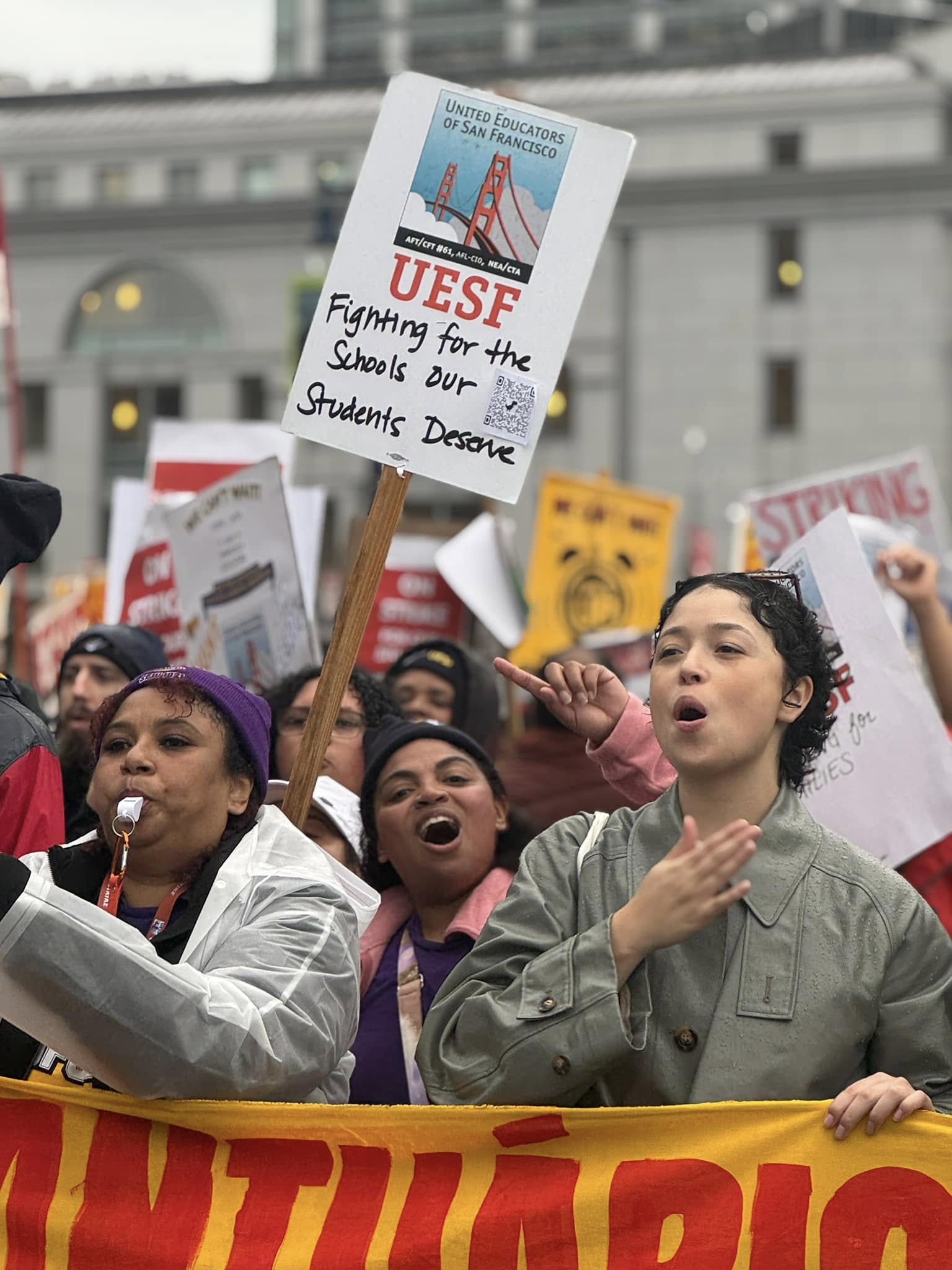 photo of woman and UESF strike holding sign that says "fighting for the schools our students deserve."